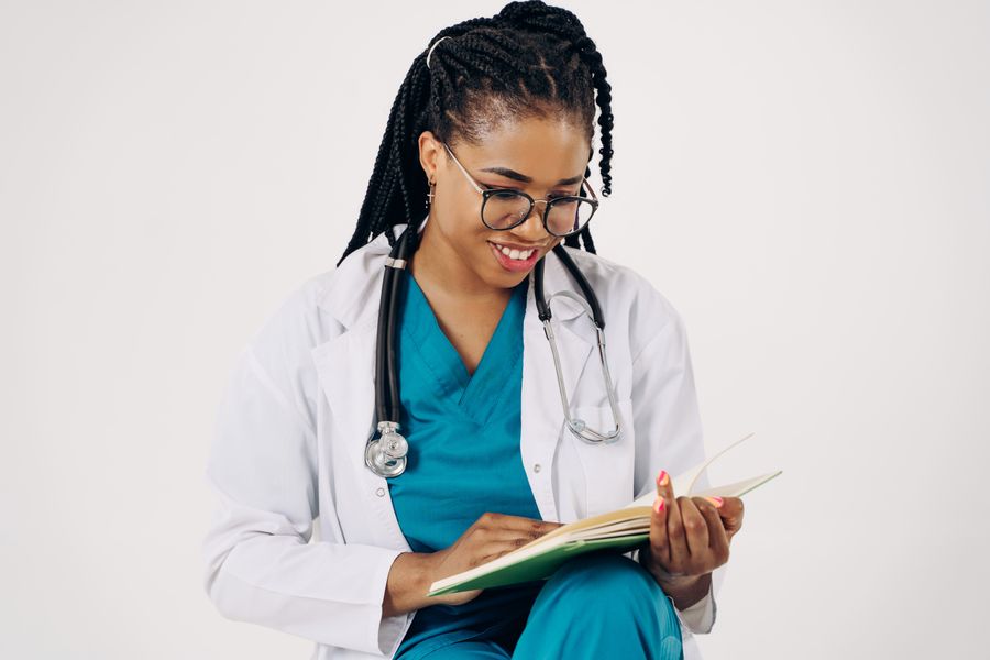 Médica sonriendo mientras revisa un cuaderno